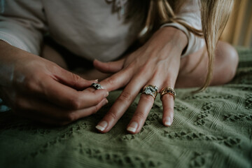 Obraz na płótnie Canvas Woman's elegant hands. Trying on wedding engagement rings. Green background. Modern bride.