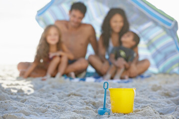 Big family, sand and box on beach with umbrella, spade or bucket for playing on ocean coast. Blue...