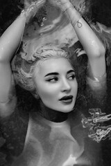 Portrait of a young beautiful blonde girl in a vintage style bathroom. Black and white photo.