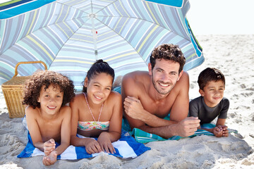 Happy family, portrait and beach umbrella for bonding, vacation or outdoor holiday weekend...