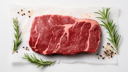 Top View. Raw beef steak with rosemary and spices for cooking on white background.