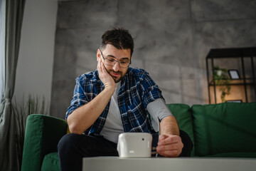 one adult caucasian man measure check blood pressure at home
