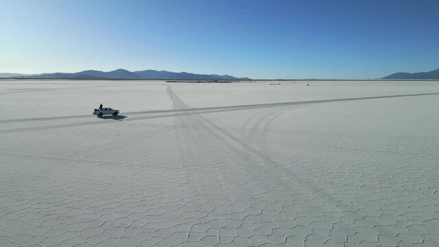 Pickup truck traveling over Salinas Grandes, Argentina. Aerial tracking shot
