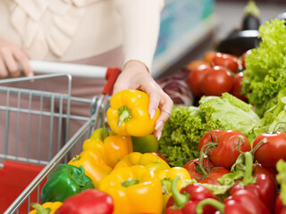 Woman buying fresh vegetables at the supermarket