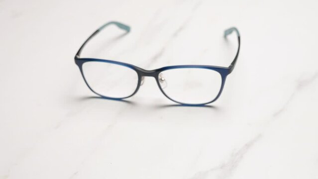 Detail of blue prescription glasses on a light background