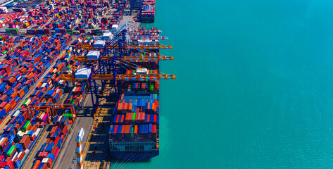 Global transportation and logistic business. Aerial top view over international containers cargo ship at industrial import-export port prepare to load containers with big container loader ship. - obrazy, fototapety, plakaty