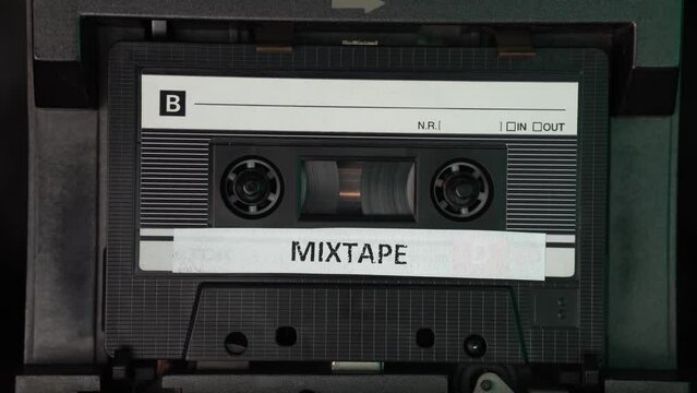Mixtape Music Audio Cassette Tape Playing in Vintage Deck Player, Close Up