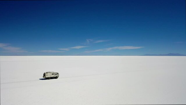 Aerial Shot RV Expedition Truck Tracking Salar Uyuni Bolivia Blue Sky Salty Road