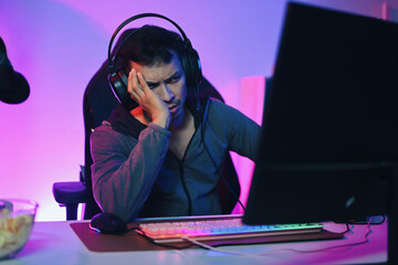 Upset young man feeling sad disappointed after being defeated in online video game.
