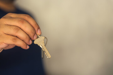 Human hand holding house key. Concept of new life and new home. Businessman holding key