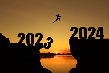 Man jumping 2023-2024. man jumping over cliff on sunset background,Business concept idea