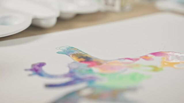 Closeup of watercoloring paint brush dabbing and swirling across vibrant art piece