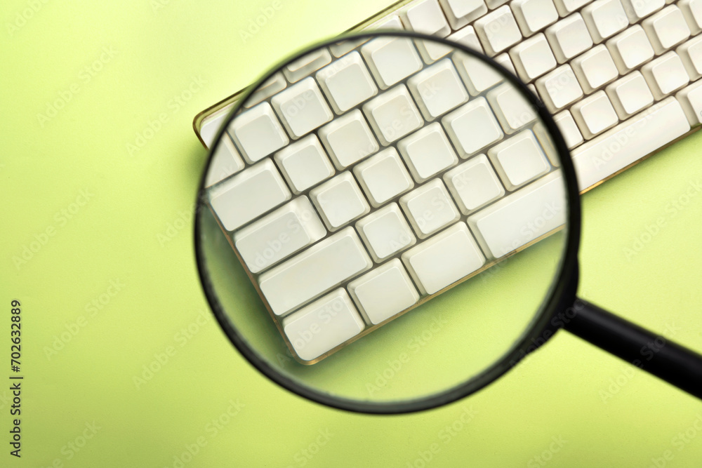 Poster a closeup view of a magnifying glass focuses on a computer keyboard button
