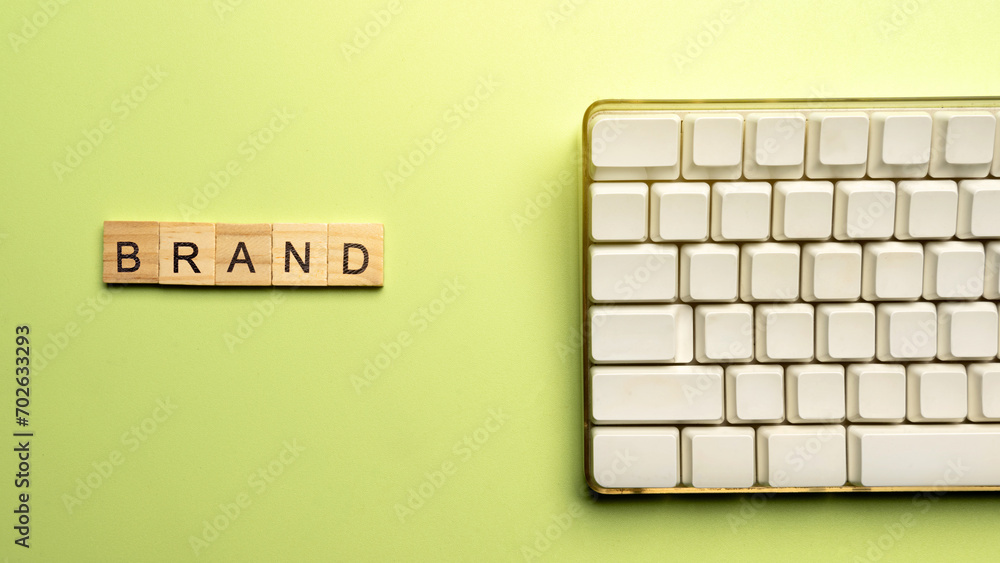 Poster closeup view of a wooden cube with brand word and computer keyboard