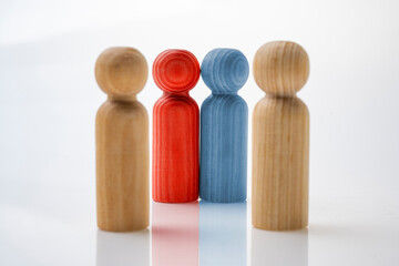Red and blue wooden figures stand out from the four wooden figures