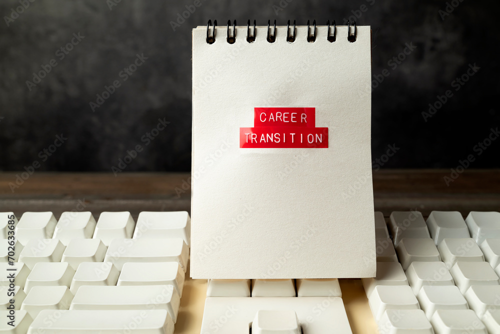 Poster closeup view of a computer keyboard with career transition text on a notebook