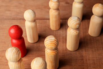 Red wooden figures stand out from the crowd of wooden figures
