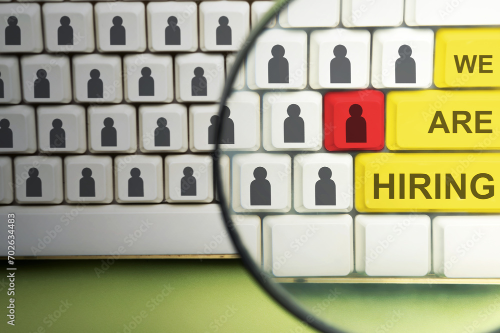 Poster the magnifying glass focuses on the computer keyboard button with we are hiring words