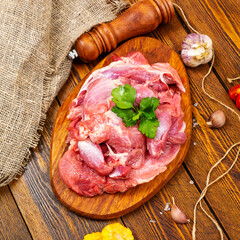 Fresh red turkey meat on a cutting board, top view, on a dark wooden background