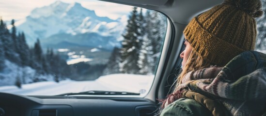 Woman enjoying winter mountain landscape while exploring in a car. - obrazy, fototapety, plakaty