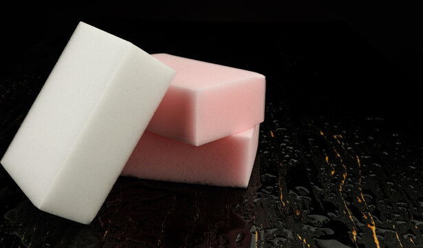 Melamine sponge on a black wet background. Beautiful drops of water around a melamine sponge.