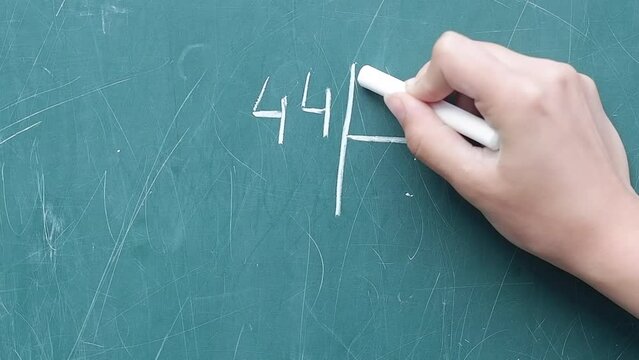 Children hand writing on green board, study. Back To School, school blackboard with mathematics. 