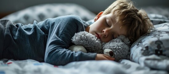 Boy sleeping on bed with stuffed toy as pillow. - obrazy, fototapety, plakaty