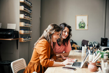 Business discussion. Two attractive young female employees discussing their small business in the...