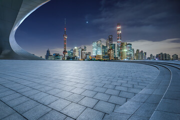 Empty square floor and bridge with modern city buildings at night in Shanghai