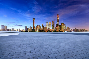 Empty square floor and modern city building scenery at night in Shanghai