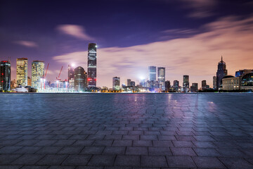 Empty square floor and modern city buildings at night in Shanghai