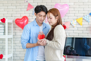 Asian young handsome male boyfriend standing smiling playing cuddling with beautiful female...