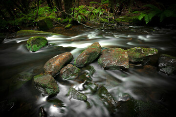 Tranquil, picturesque landscape with a shallow river gently flowing over a bed of rocks