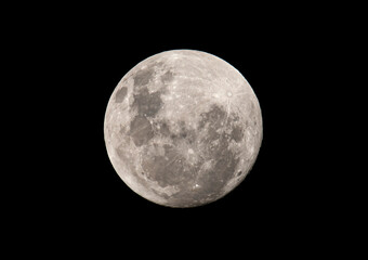Full moon in the night sky illuminated by a bright white light