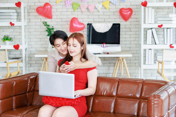 Asian young handsome male boyfriend standing smiling behind giving red wrapped present gift box...