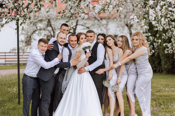 full-length portrait of the newlyweds and their friends at the wedding. The bride and groom with...