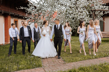 full-length portrait of the newlyweds and their friends at the wedding. The bride and groom with...