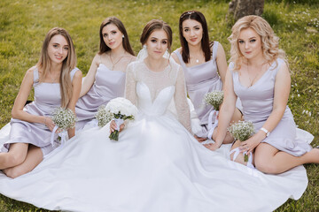 Group portrait of the bride and bridesmaids. A bride in a wedding dress and bridesmaids in silver...