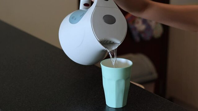 Pouring Water from Kettle into Cup