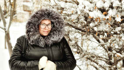 Portrait of a young woman with glasses in a park on a winter day. 6