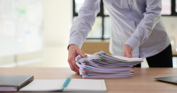 Stack of business documents with paper clips on wooden table indoors