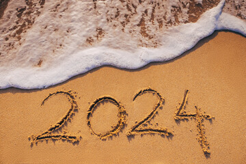 Happy New Year 2024 Text on Tropical Beach Sand, Caribbean sea sunrise and waves on the shore.