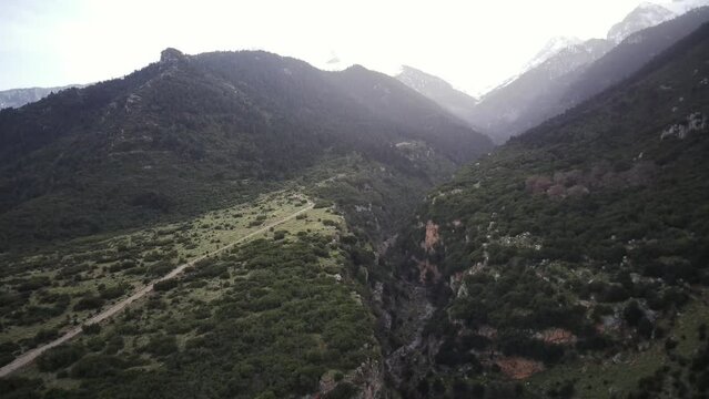Drone footage of Velitsa Gorge with mountains in the background at sunset in Phthiotis, Greece