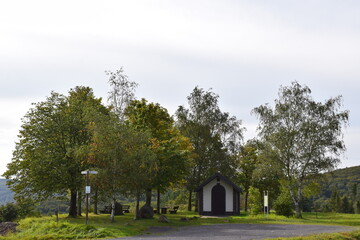 Fototapeta na wymiar chapel between autumn trees