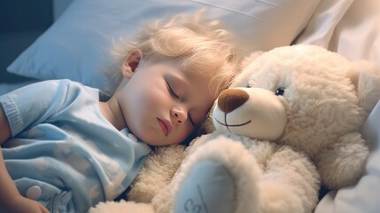 A little boy with blonde hair sleeps on a bed with a soft toy bear in her arms. A child's sweet sleep - obrazy, fototapety, plakaty