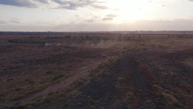 Aerial view drone flying over a track leaving dust behind in desert