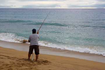 Fisherman with a rod on the beach.