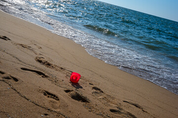 Plastic can scoops up pink sand at Pattaya beach.
