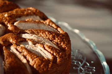 Sponge cake with fruit slices on white table top view.
