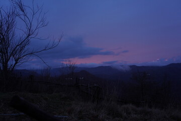 tramonto nuvoloso con cielo colorato e magico di inverno, alberi secchi, Torriglia, liguria